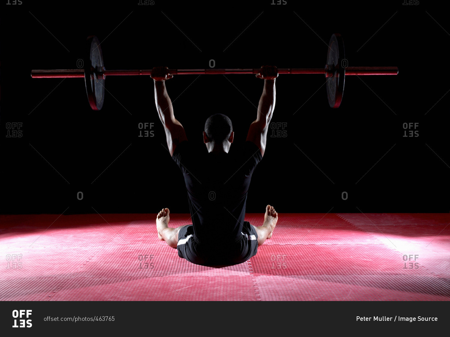 Man Lifting Weight Bar Whilst Sitting