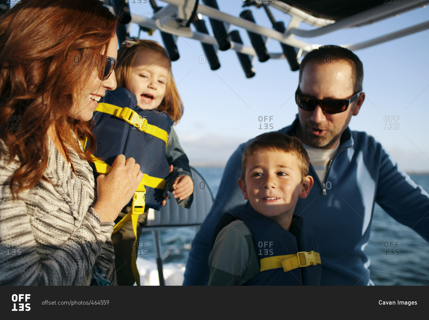 Children traveling with parents in sailboat on sunny day
