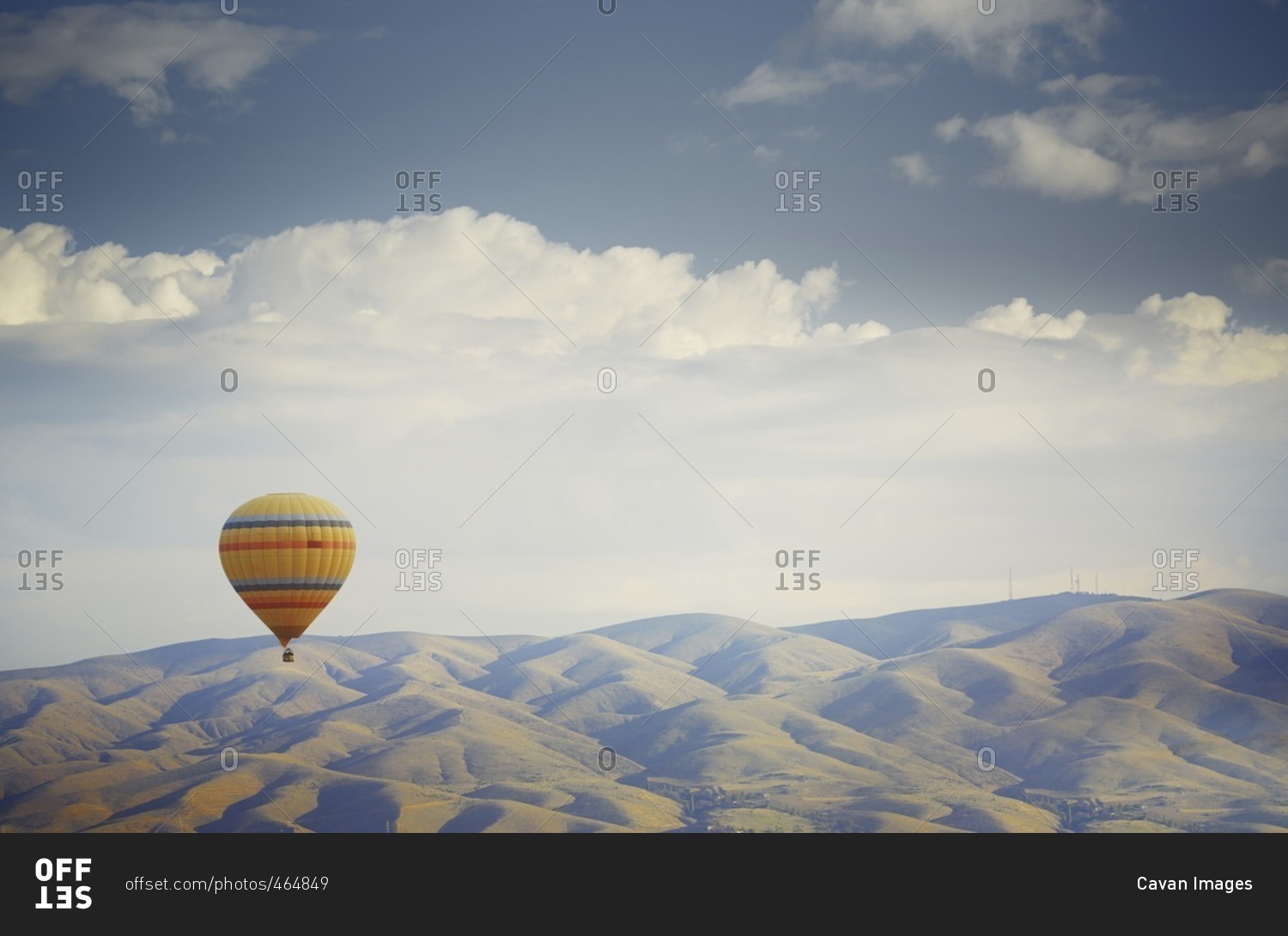 Hot air balloon flying over mountains in Cappadocia