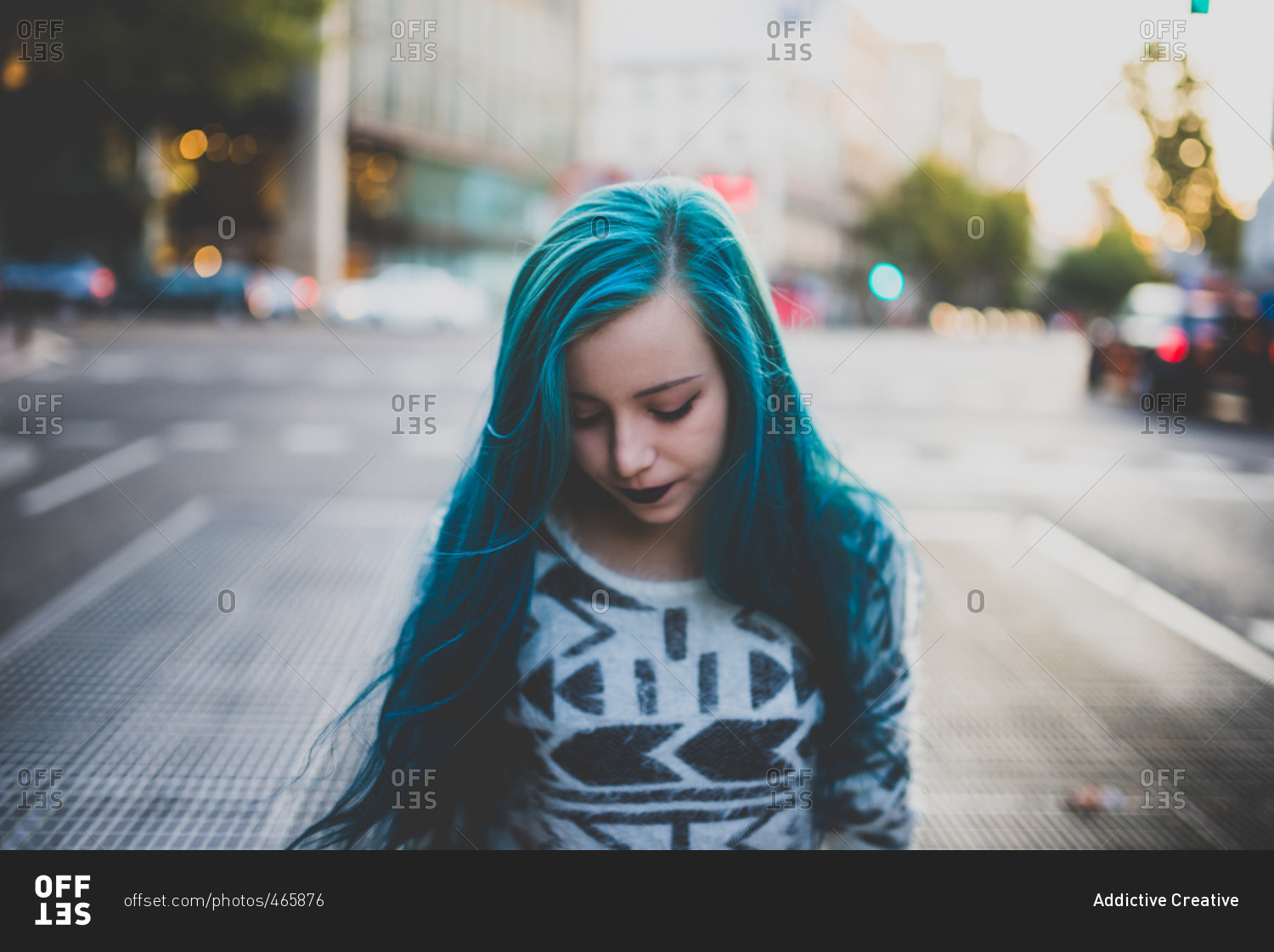 Sad punk girl with blue hair walking on a city street