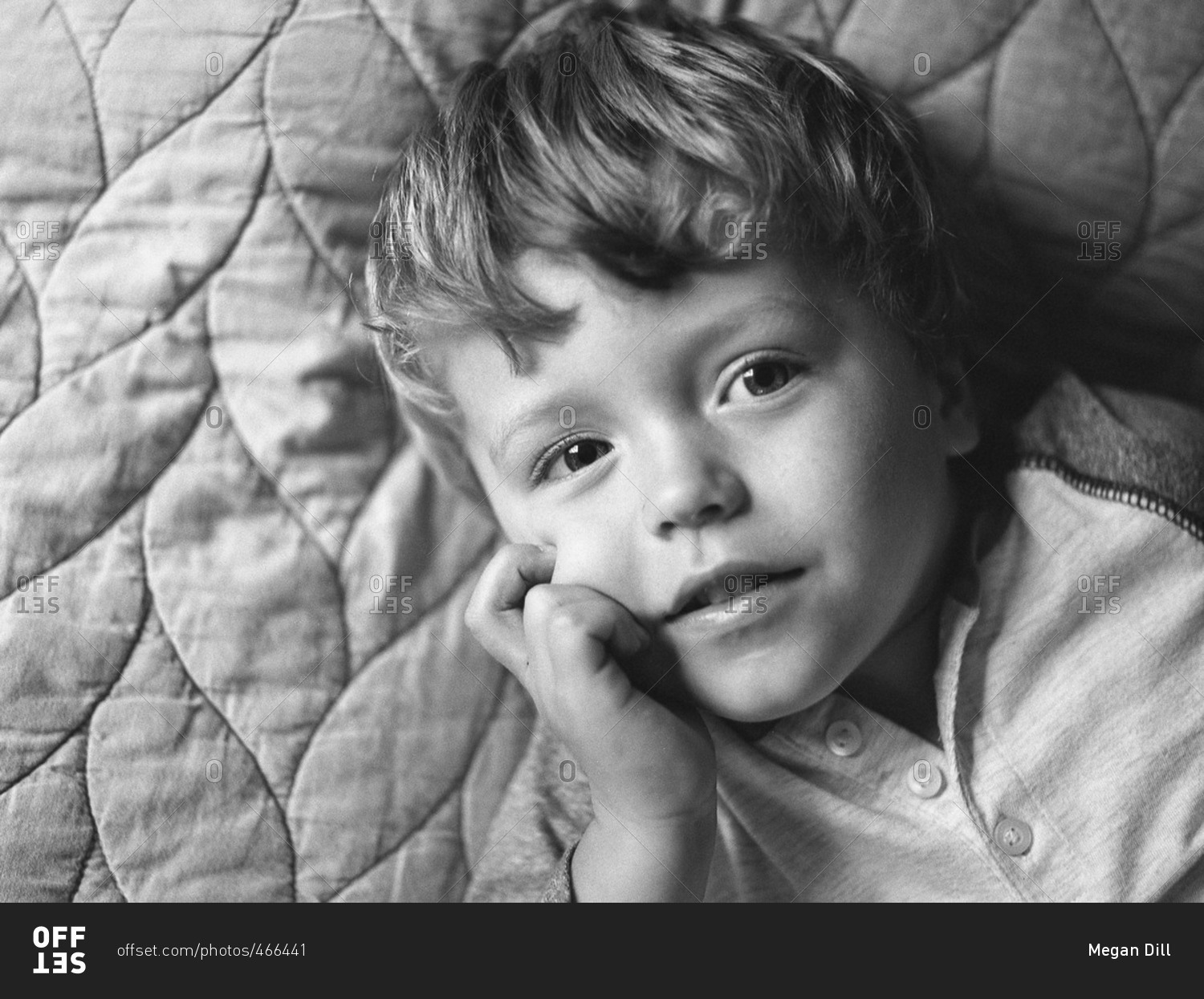 Toddler boy lying on a quilted blanket