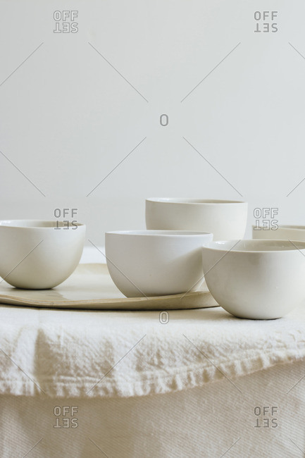 Arrangement of white porcelain bowls and platter on table