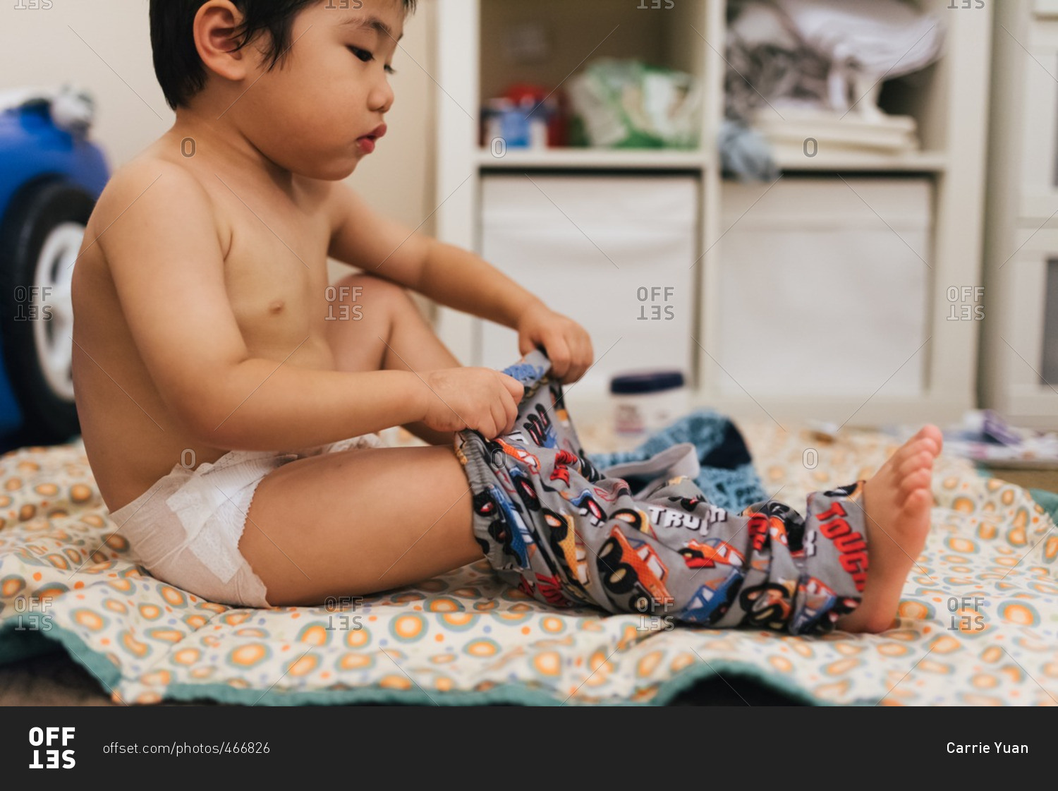 Little boy putting on pajama pants
