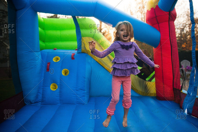 Little girl jumping in a colorful bounce house
