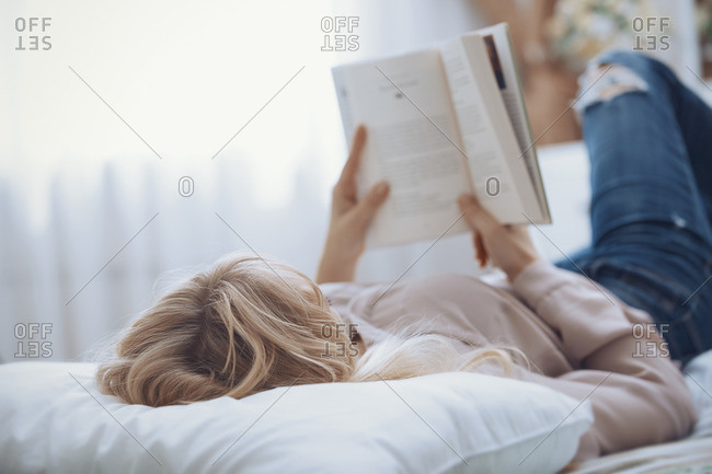 Woman Reading A Book In Bed