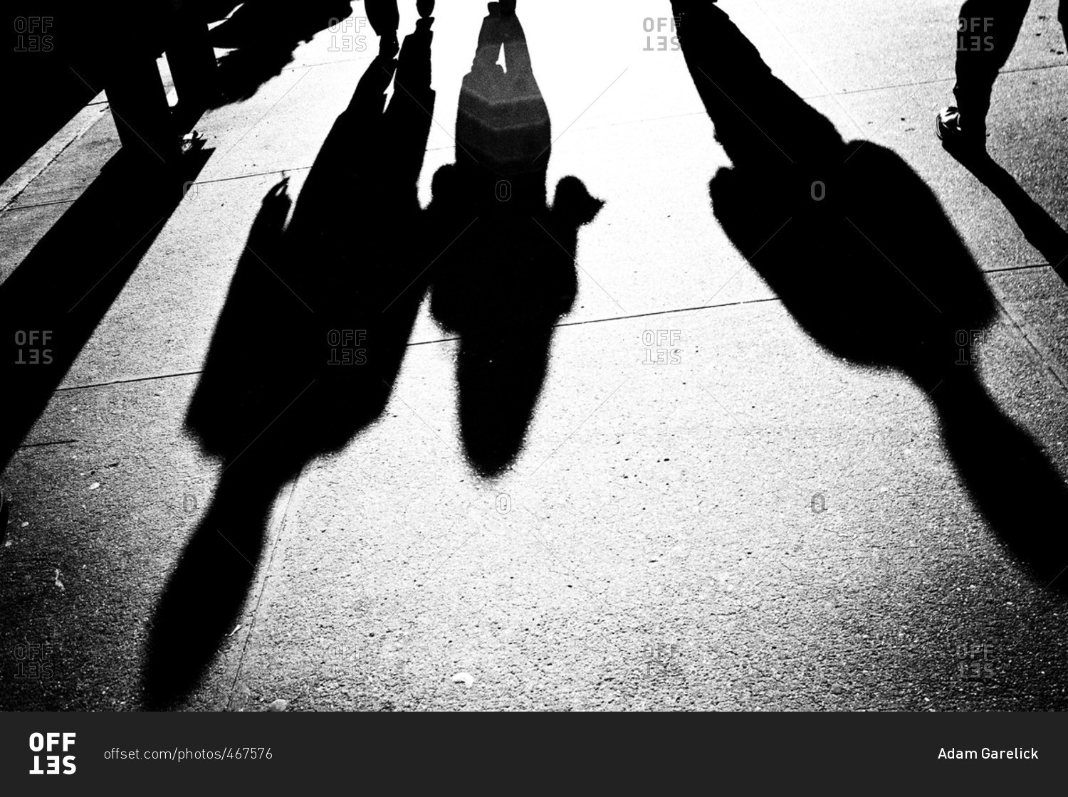 Shadows of people on city sidewalk
