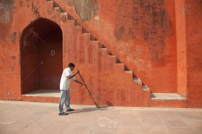New Delhi, India - October 17, 2011: Man sweeping floor at the Jantar Mantar astrological park