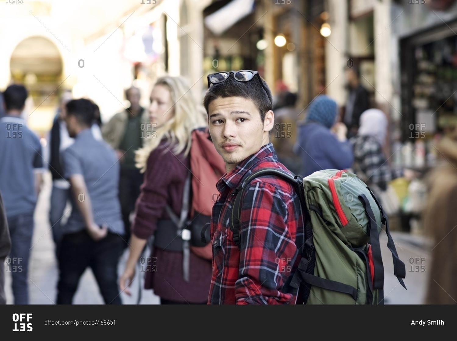 Young man with a backpack in a crowded street