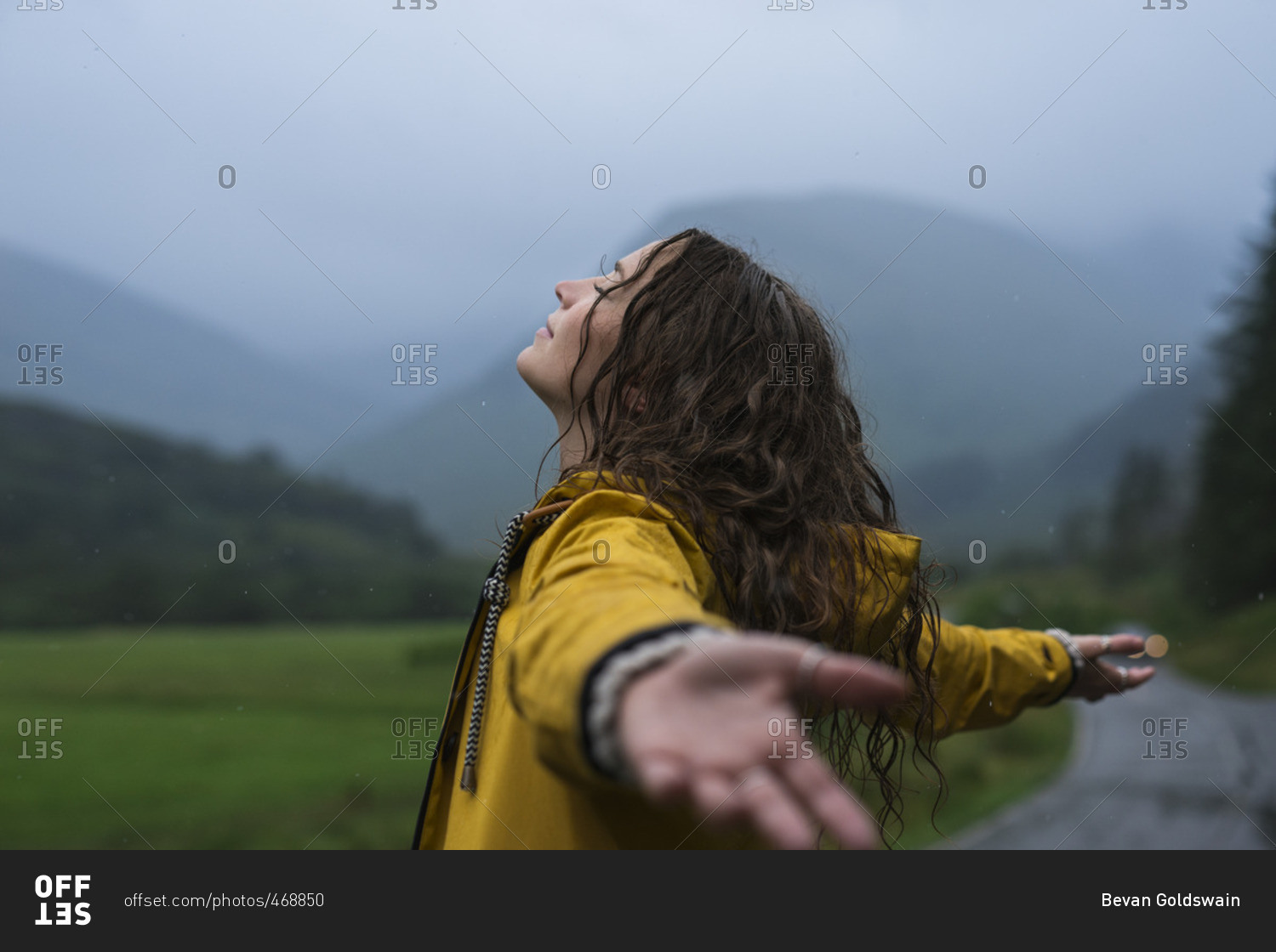 Woman in rain with open arms