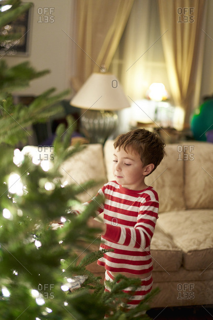 Young child trimming a Christmas tree