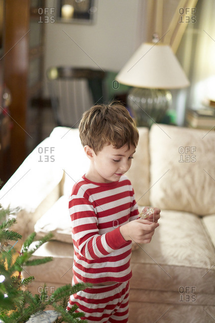 Young boy trimming a Christmas tree