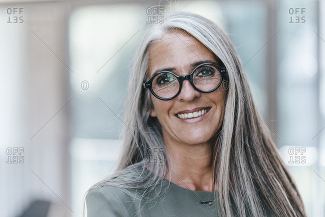 Portrait Of Smiling Woman With Long Grey Hair Stock Photo