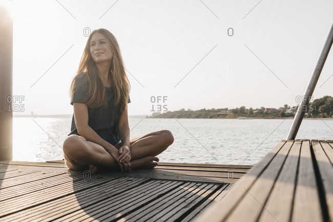 Portrait of smiling young woman relaxing on jetty