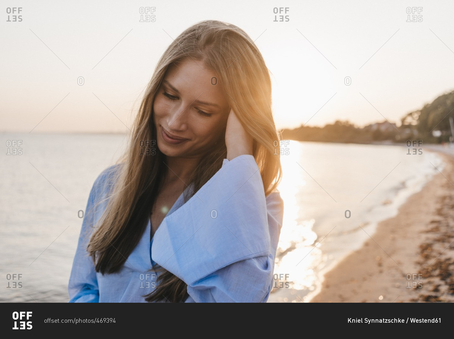 smiling young woman on the beach at sunset