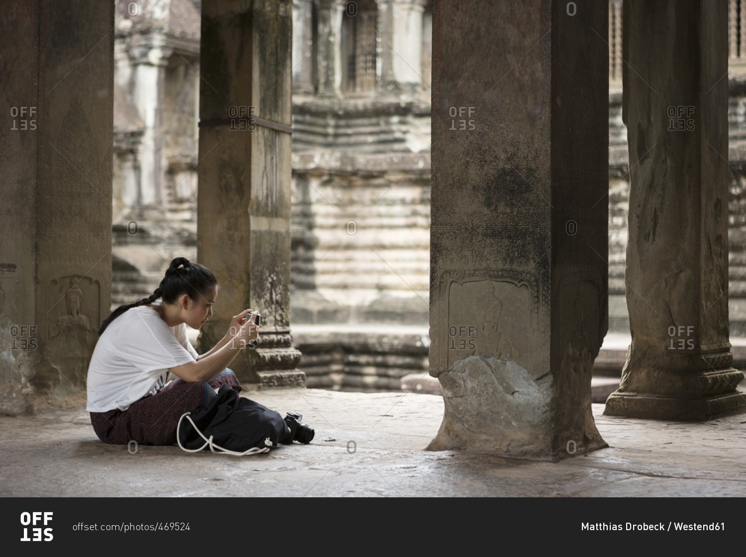 Cambodia- Siem Reap- Angkor Wat- tourist taking pictures of temple with smartphone