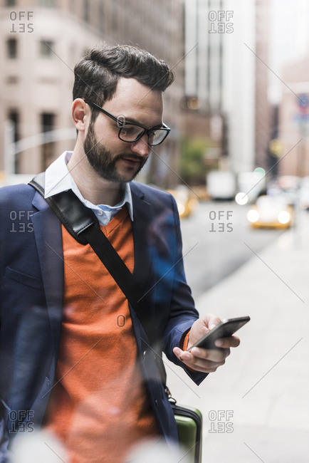 USA- New York City- Businessman using smart phone