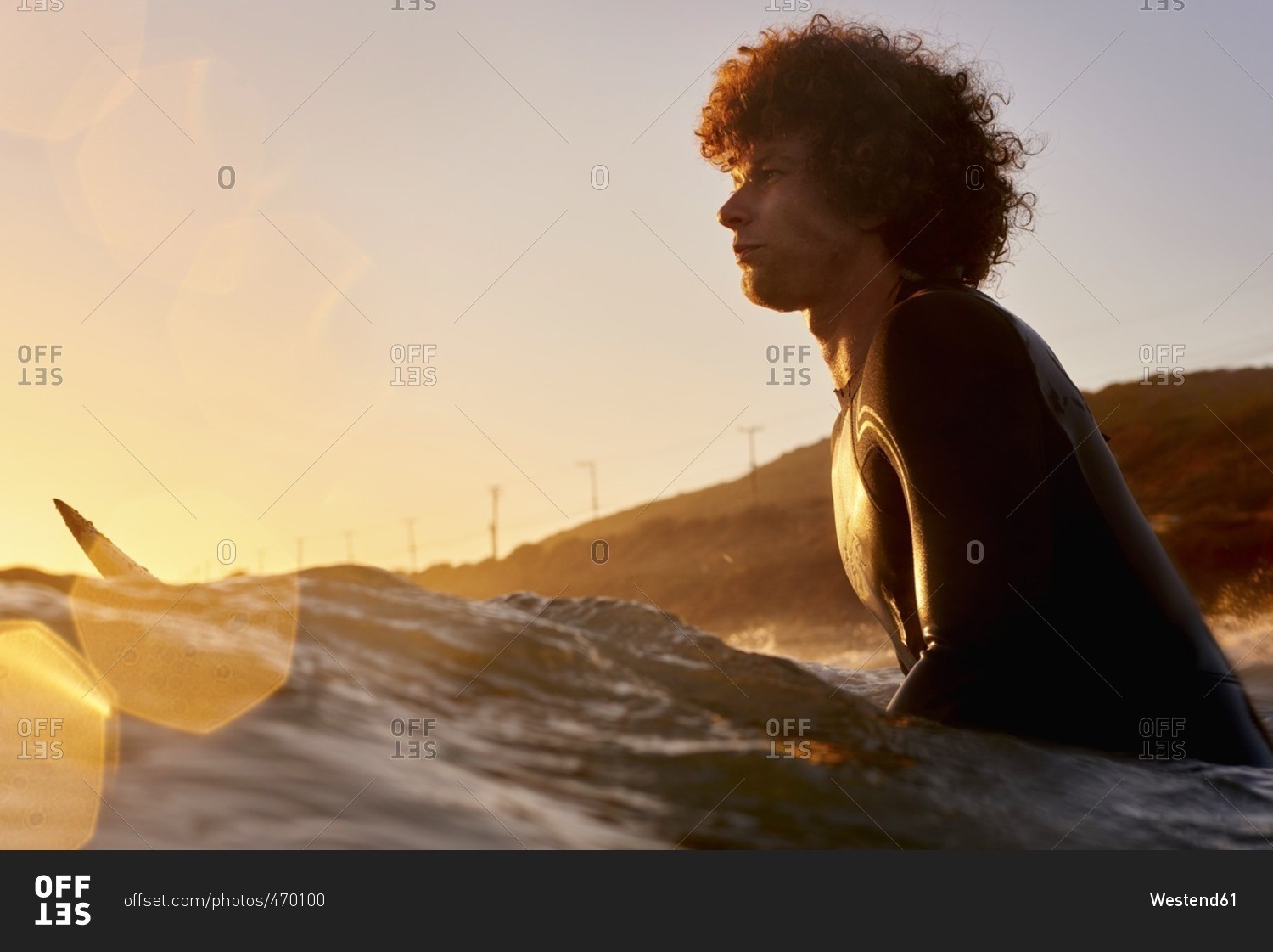 Surfer in the sea at sunset