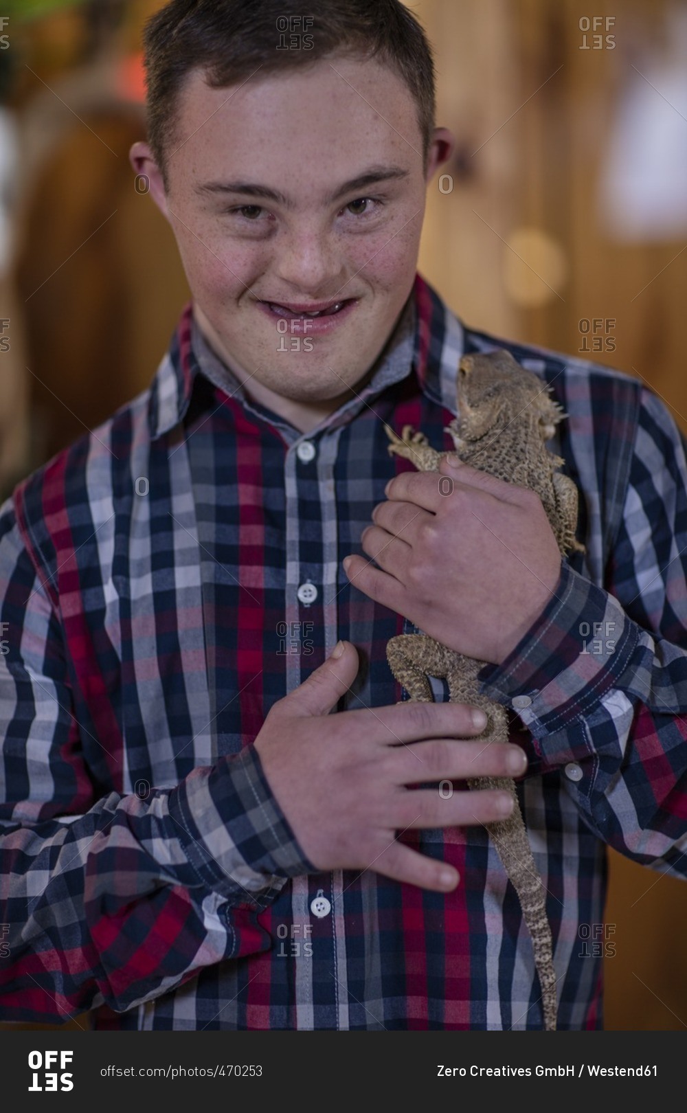 Young man with down syndrome holding a bearded dragon