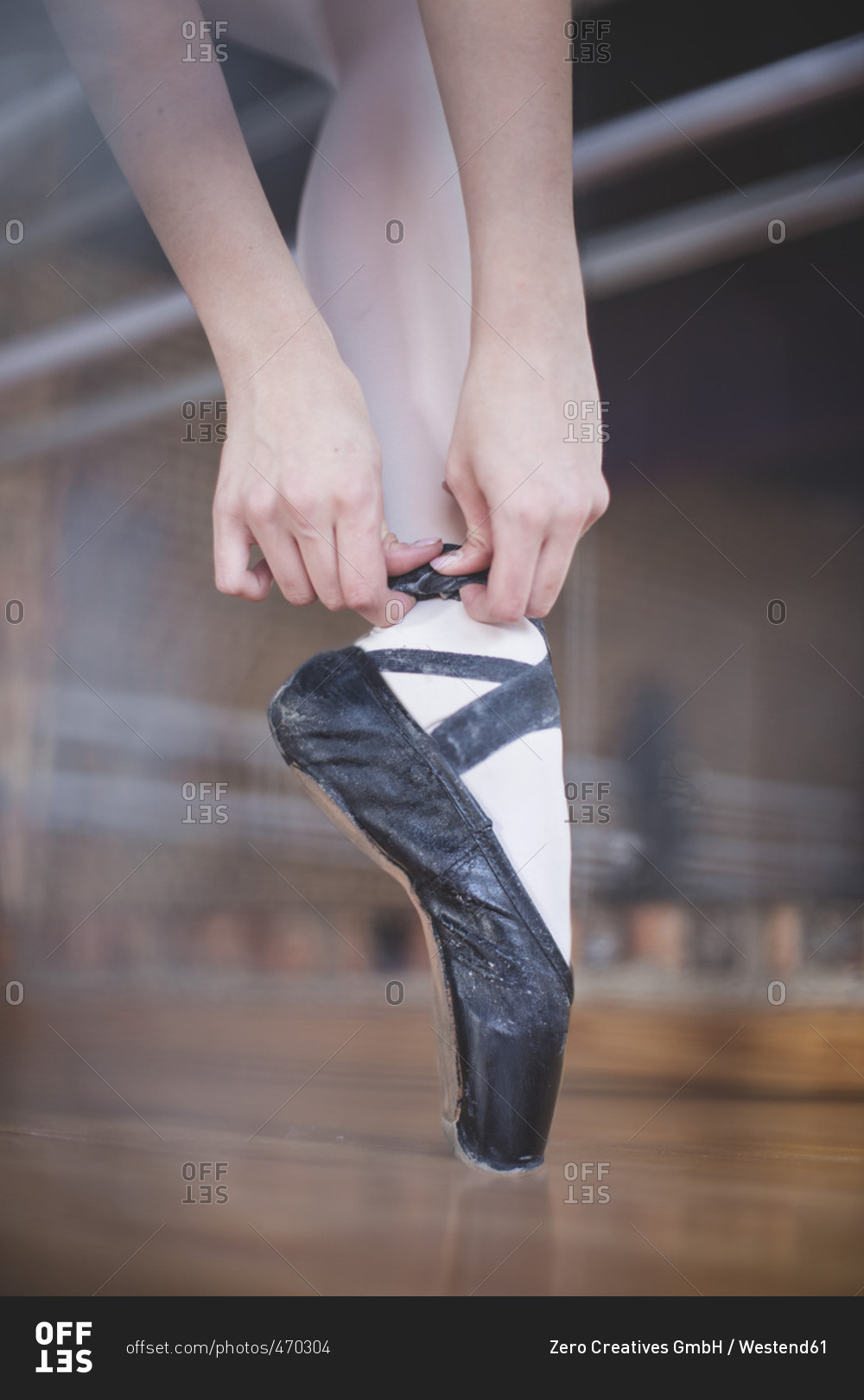 Ballet dancer putting shoes on