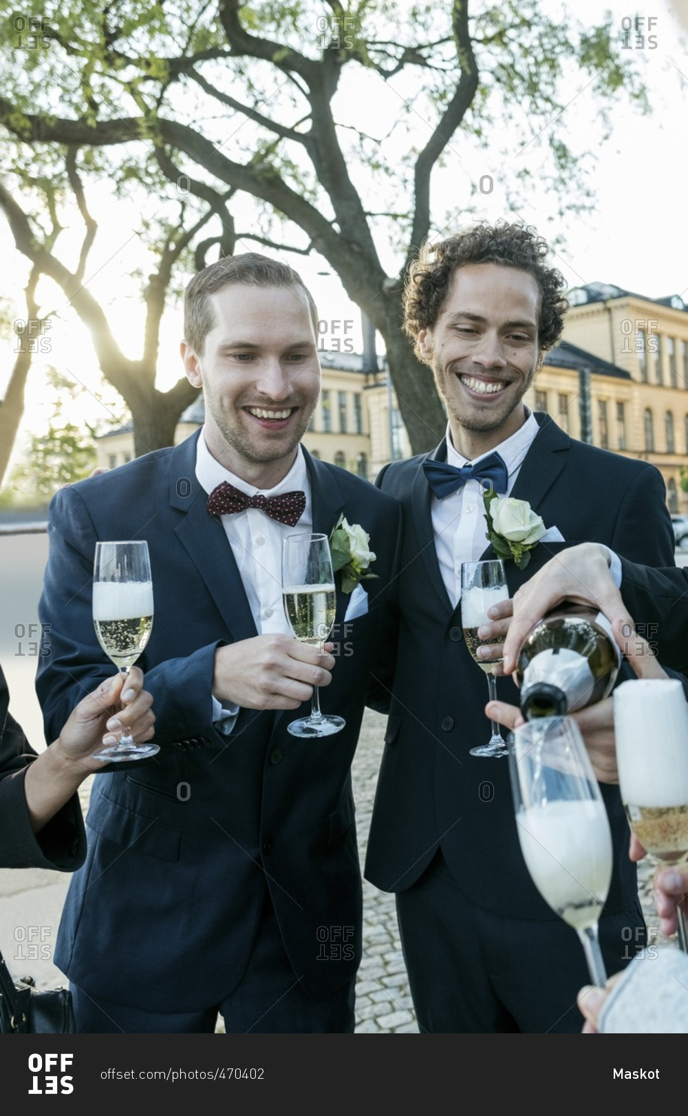 Cheerful friends with champagne during wedding ceremony