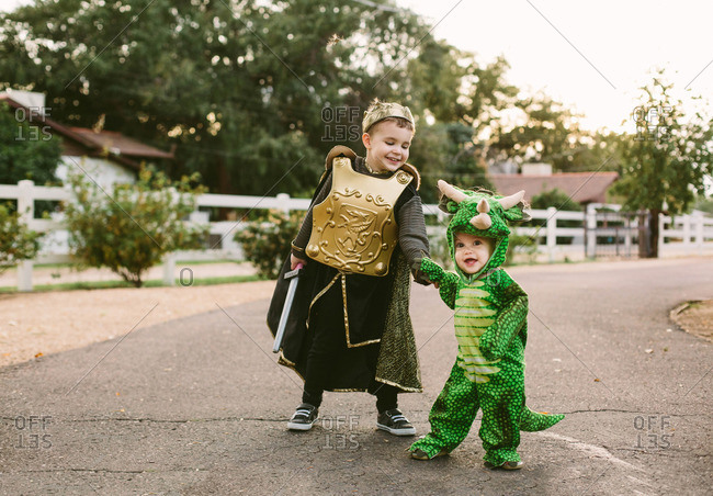 Boy and toddler in costumes in street
