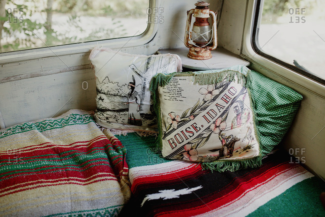 Vintage pillows and woven blankets in trailer camper