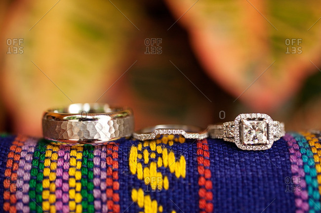 Wedding bands on a colorful woven fabric