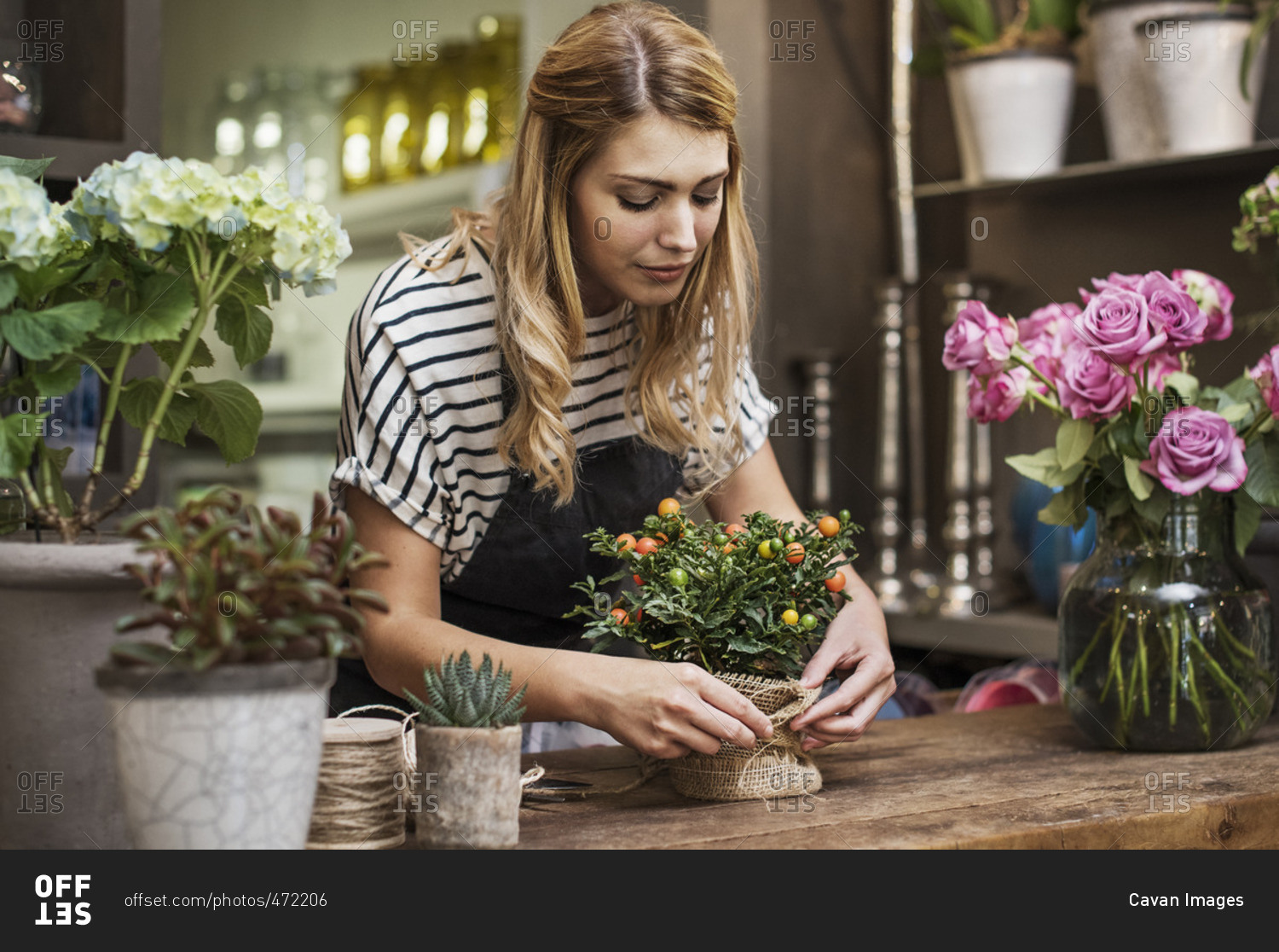 Florist arranging flowers at table in shop