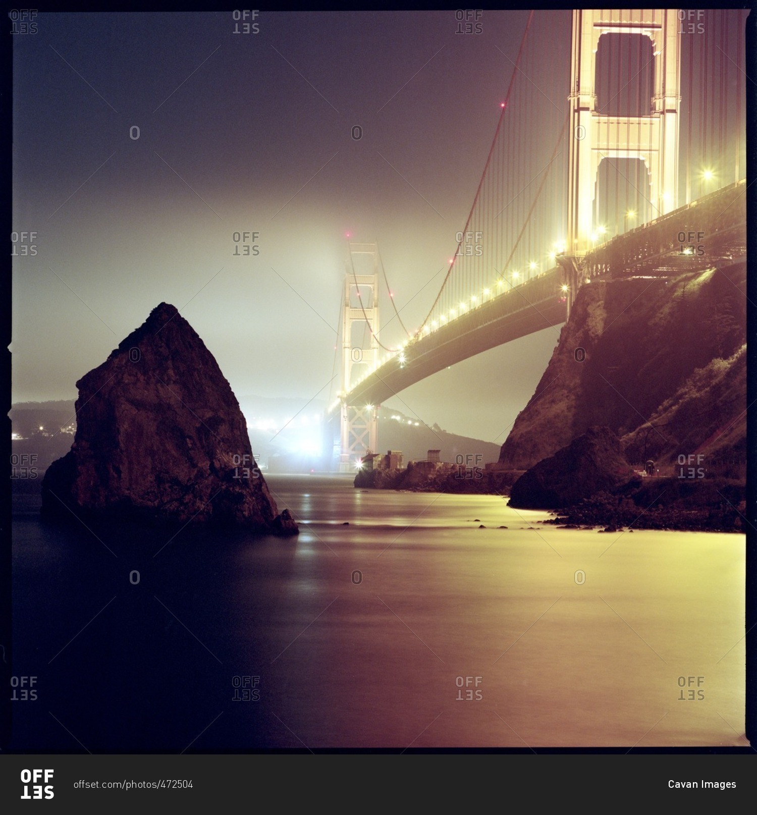 Low angle view of illuminated Golden Gate Bridge over bay during foggy weather