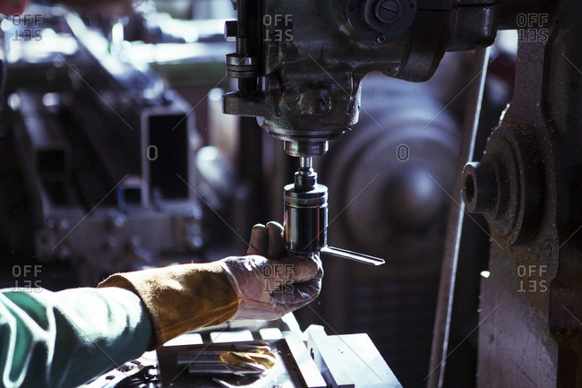 Man adjusting machine in workshop