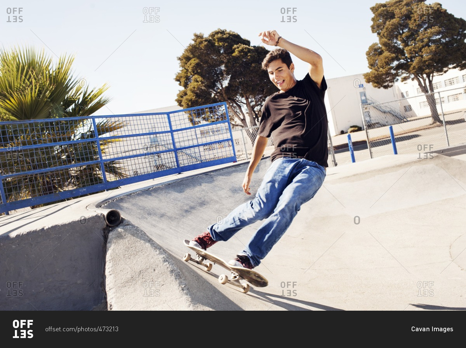 Man skateboarding on sports ramp in park against clear sky