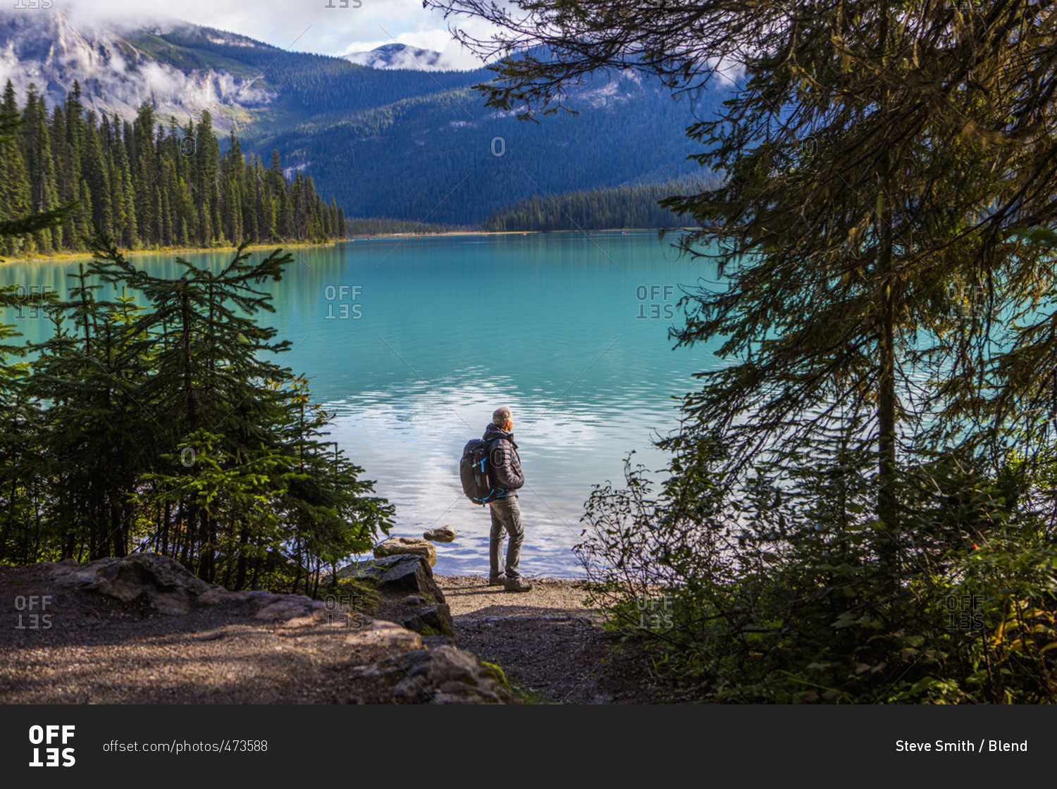 Caucasian man standing at mountain lake