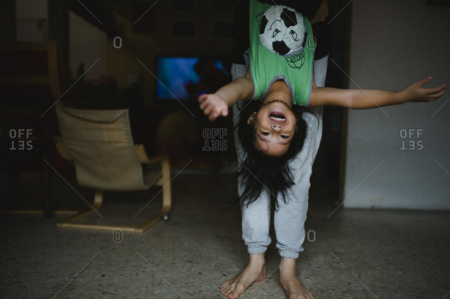 Young girl hanging upside down exposing underwear on climbing frame stock  photo - OFFSET