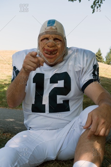 Man in creepy mask and football uniform