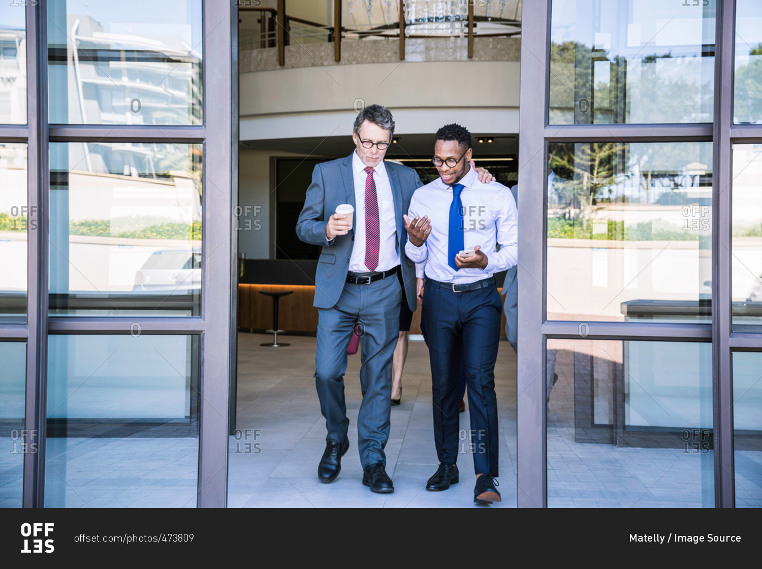 Two businessmen leaving office building