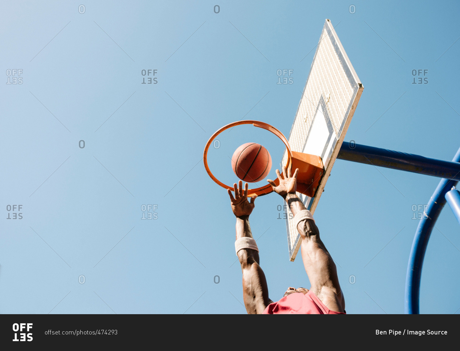 Young male basketball player throwing ball in basketball hoop
