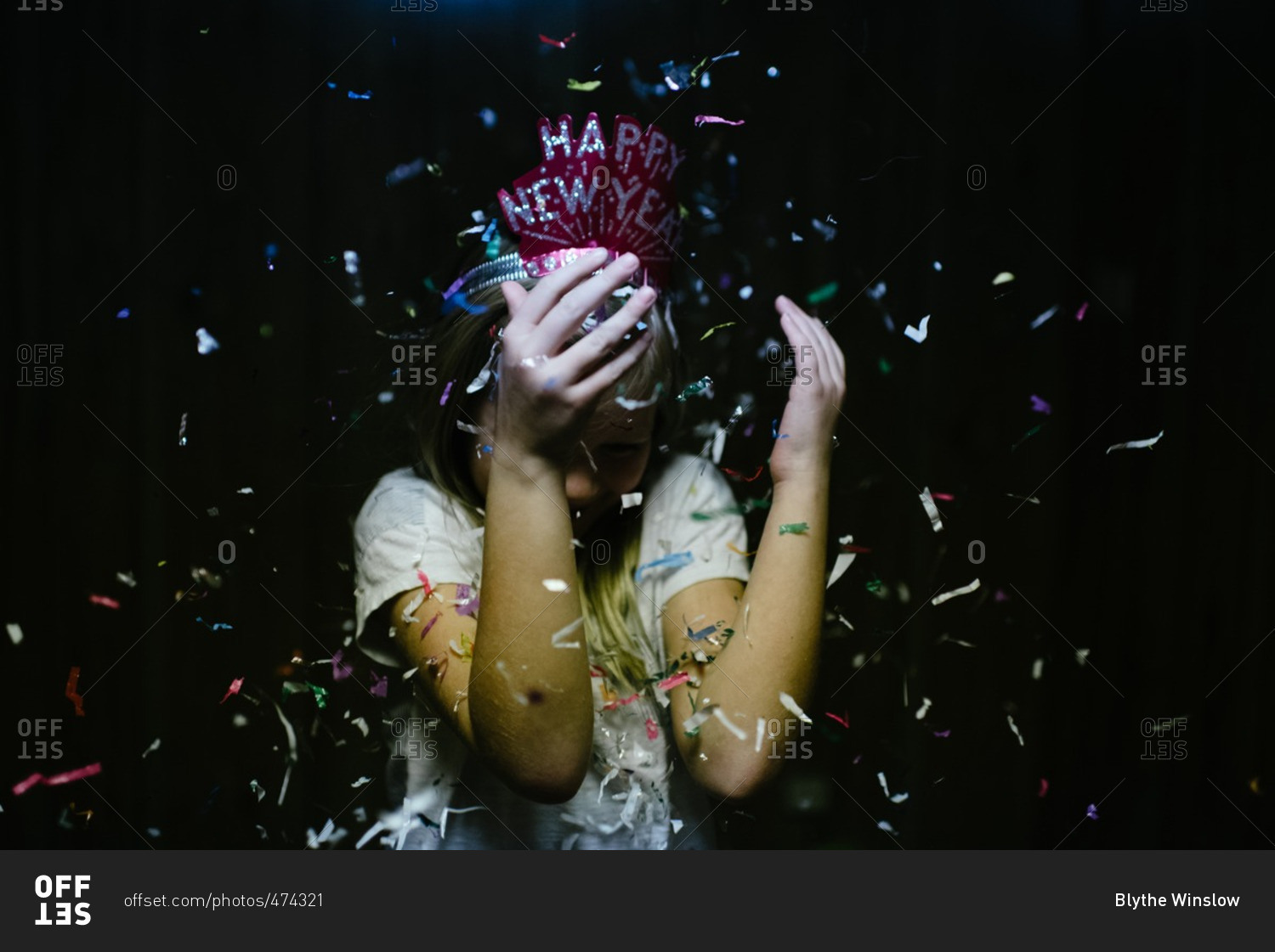 Girl hiding face from New Year's confetti