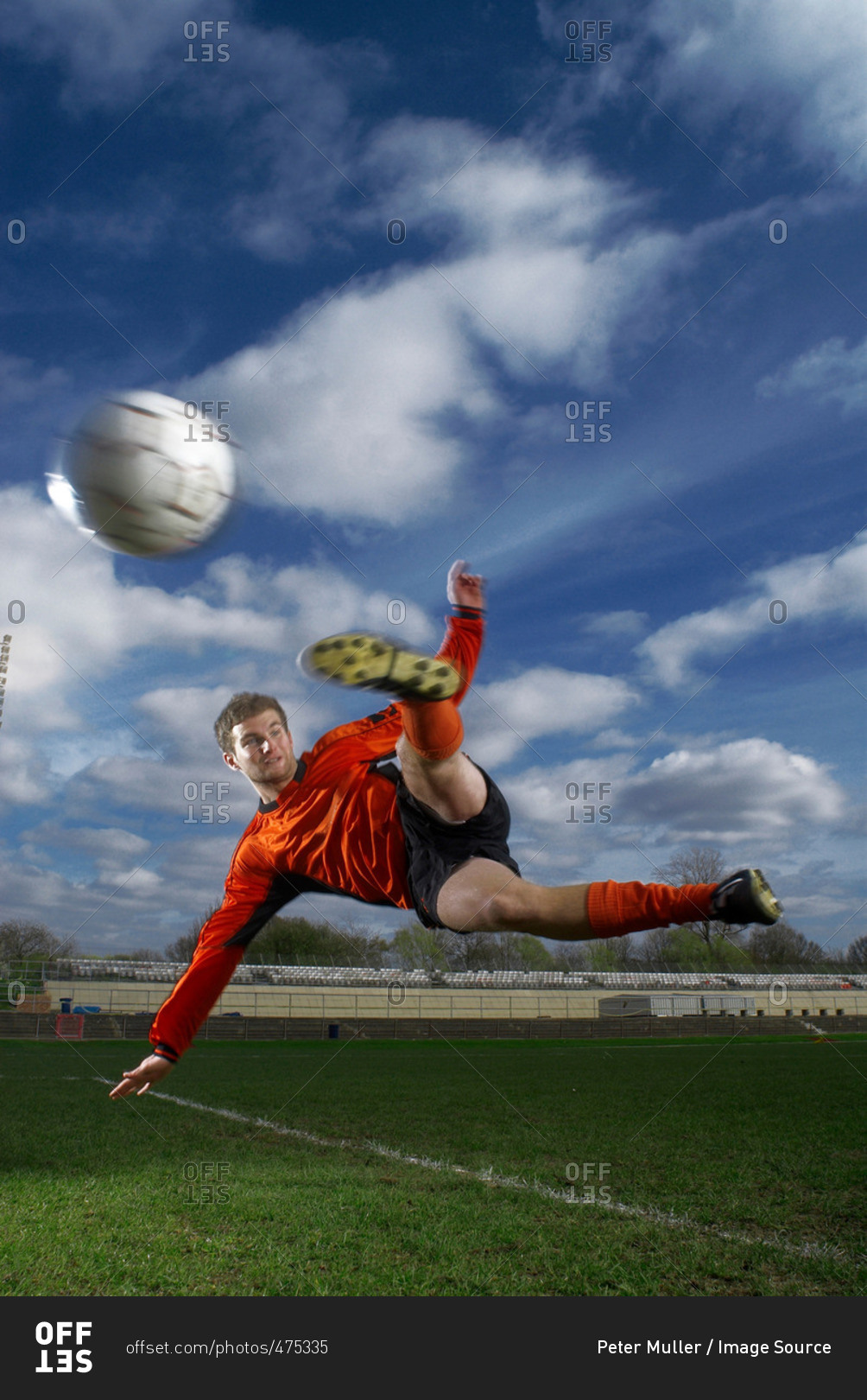 footballer volleying ball mid air