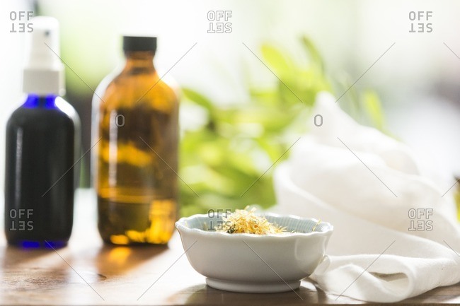 Bowl of fresh herbs and spray bottle for natural throat spray