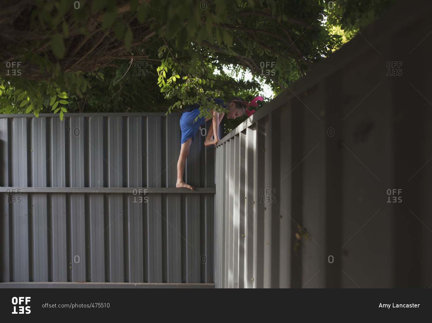Boy climbing over a fence