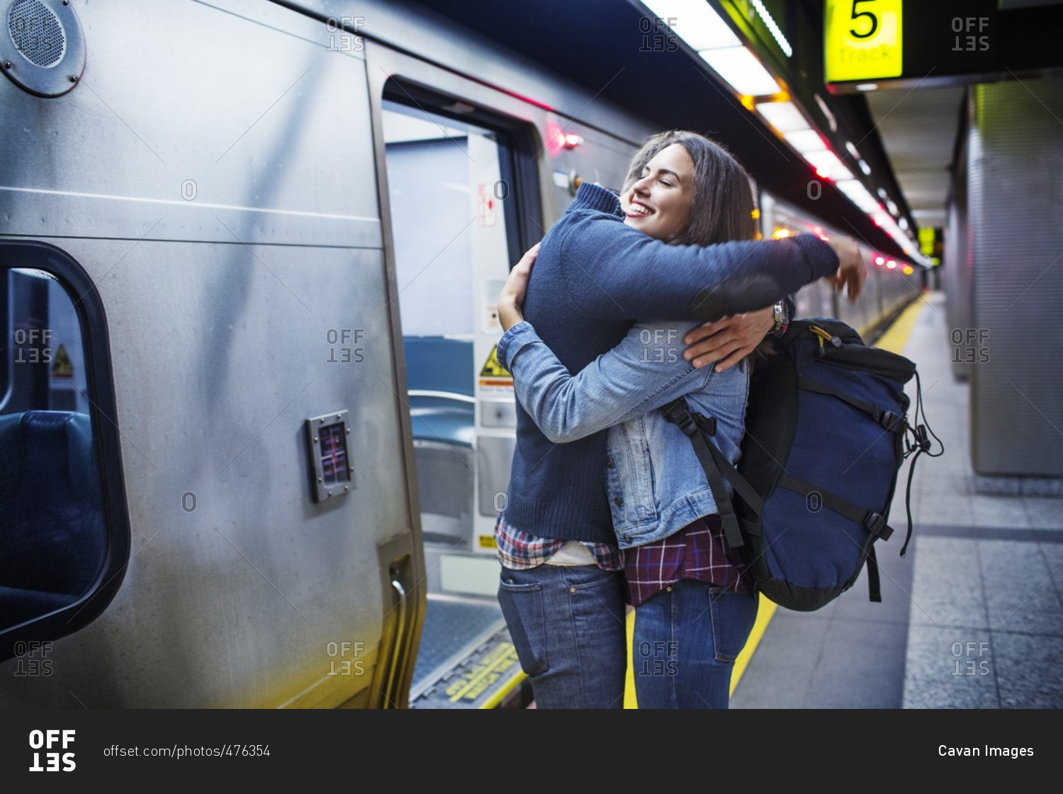 Loving couple embracing while standing at subway station by train