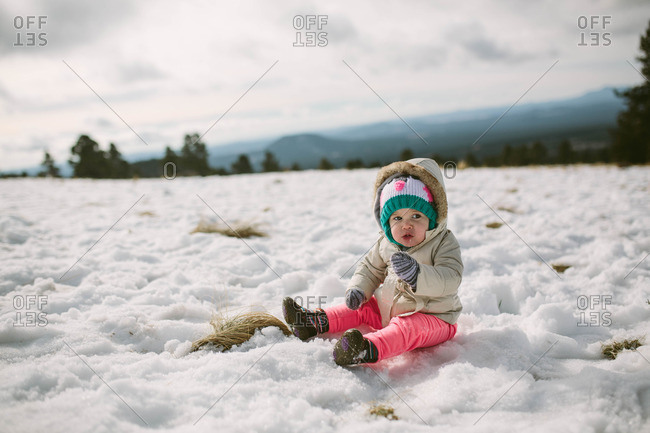 Toddler girl sitting in rural snow
