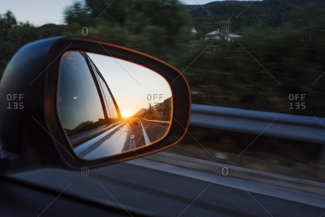 Vehicle rearview mirror reflecting sunset