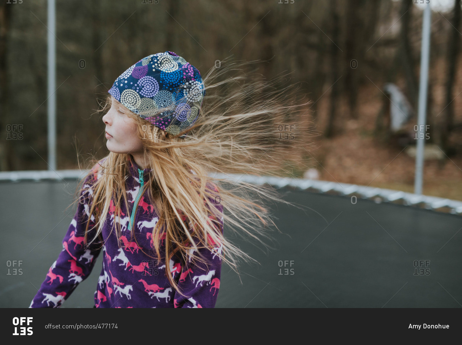 Girl on a trampoline in wind stock photo OFFSET