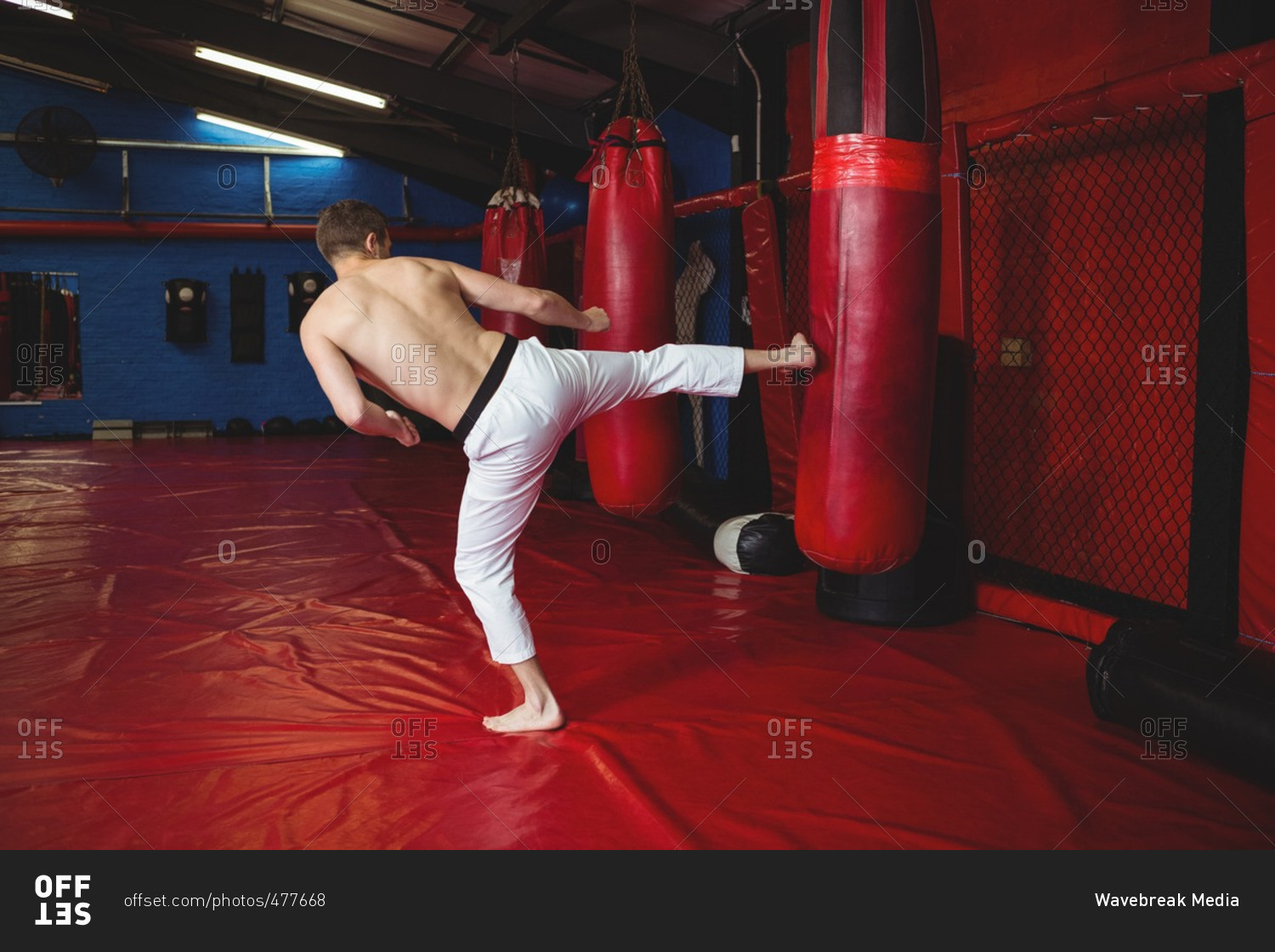Karate player practicing kickboxing in fitness studio