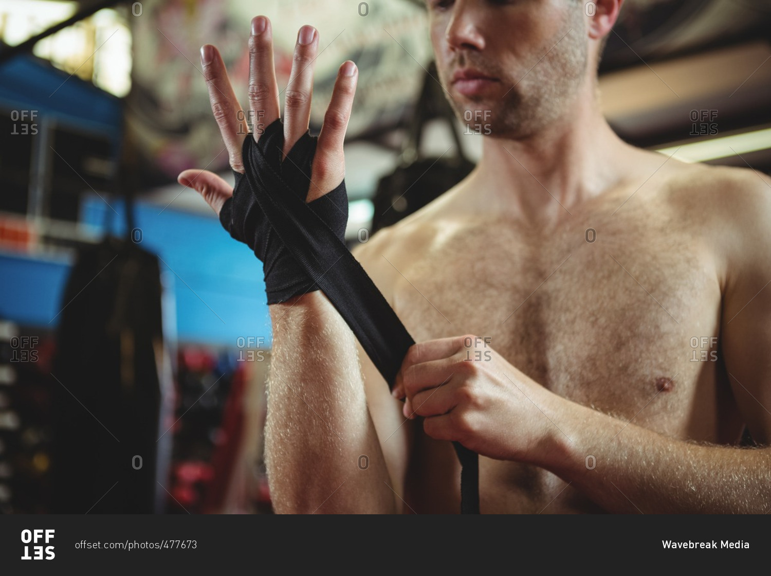 Mid section of boxer wearing black strap on wrist in fitness studio