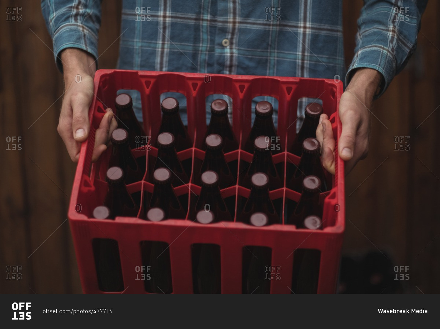 Close-up of man carrying homemade beer bottles in a crate