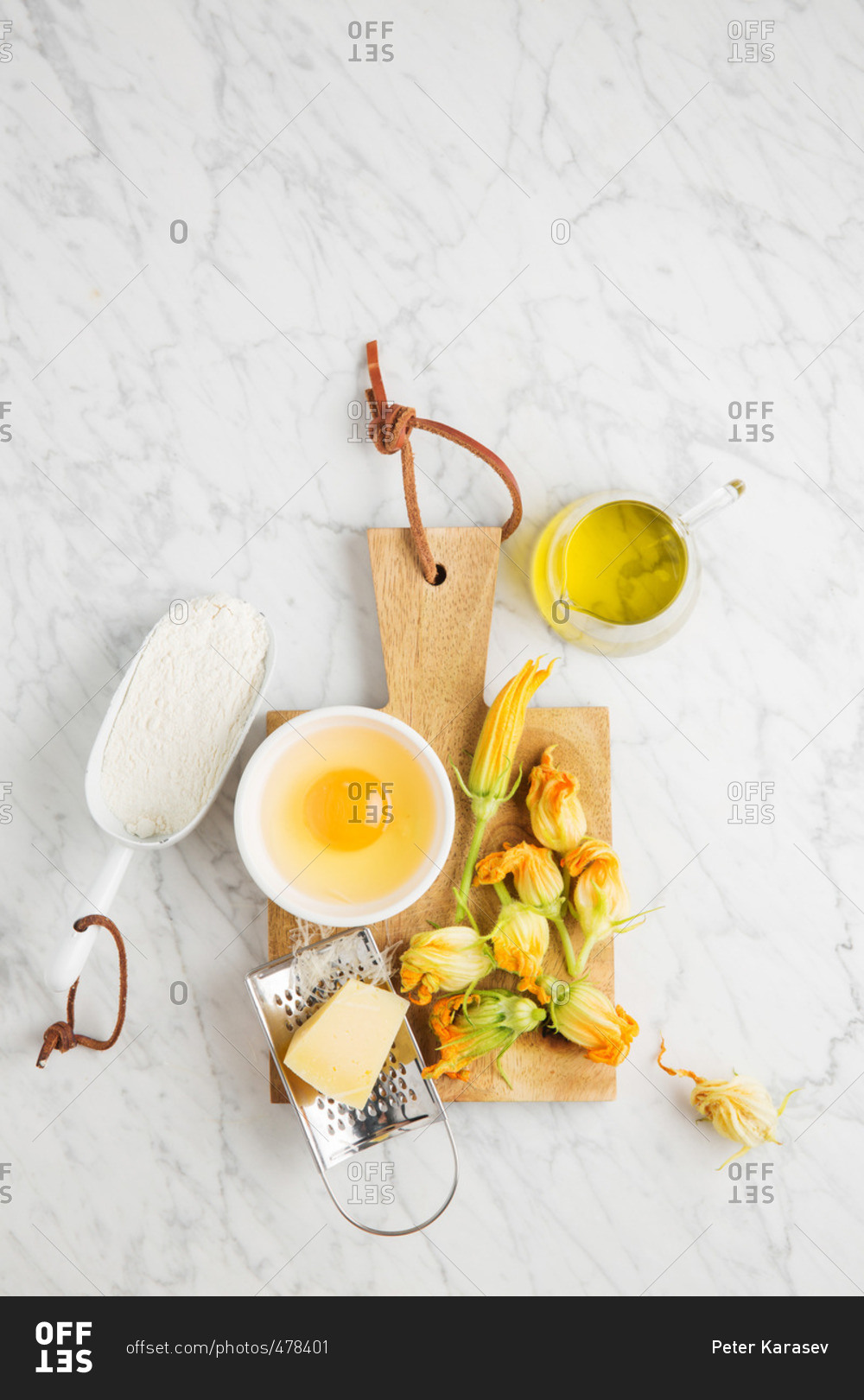 Yellow squash blossoms and ingredients on a marble counter