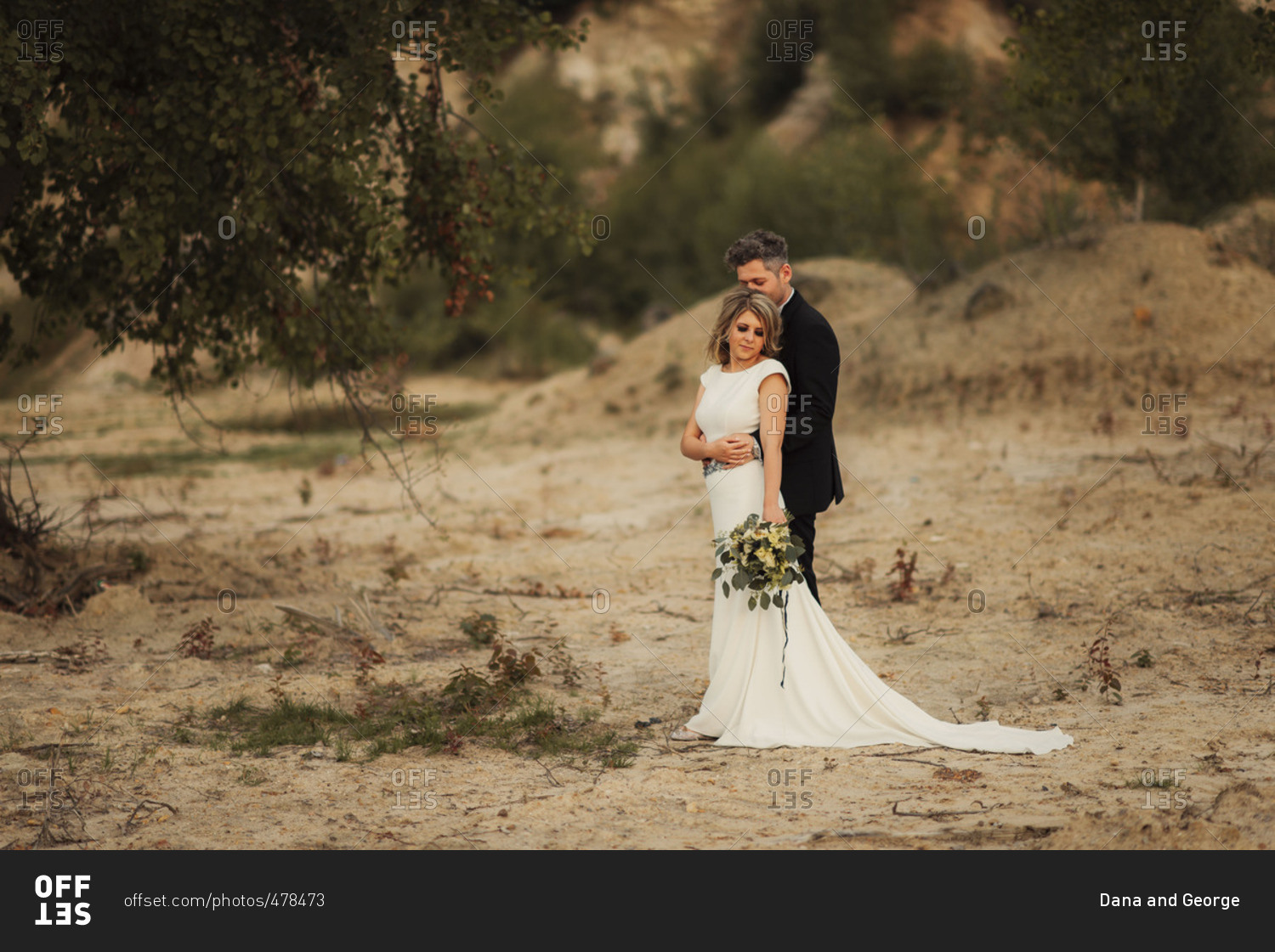 Bridal couple in embrace in remote setting