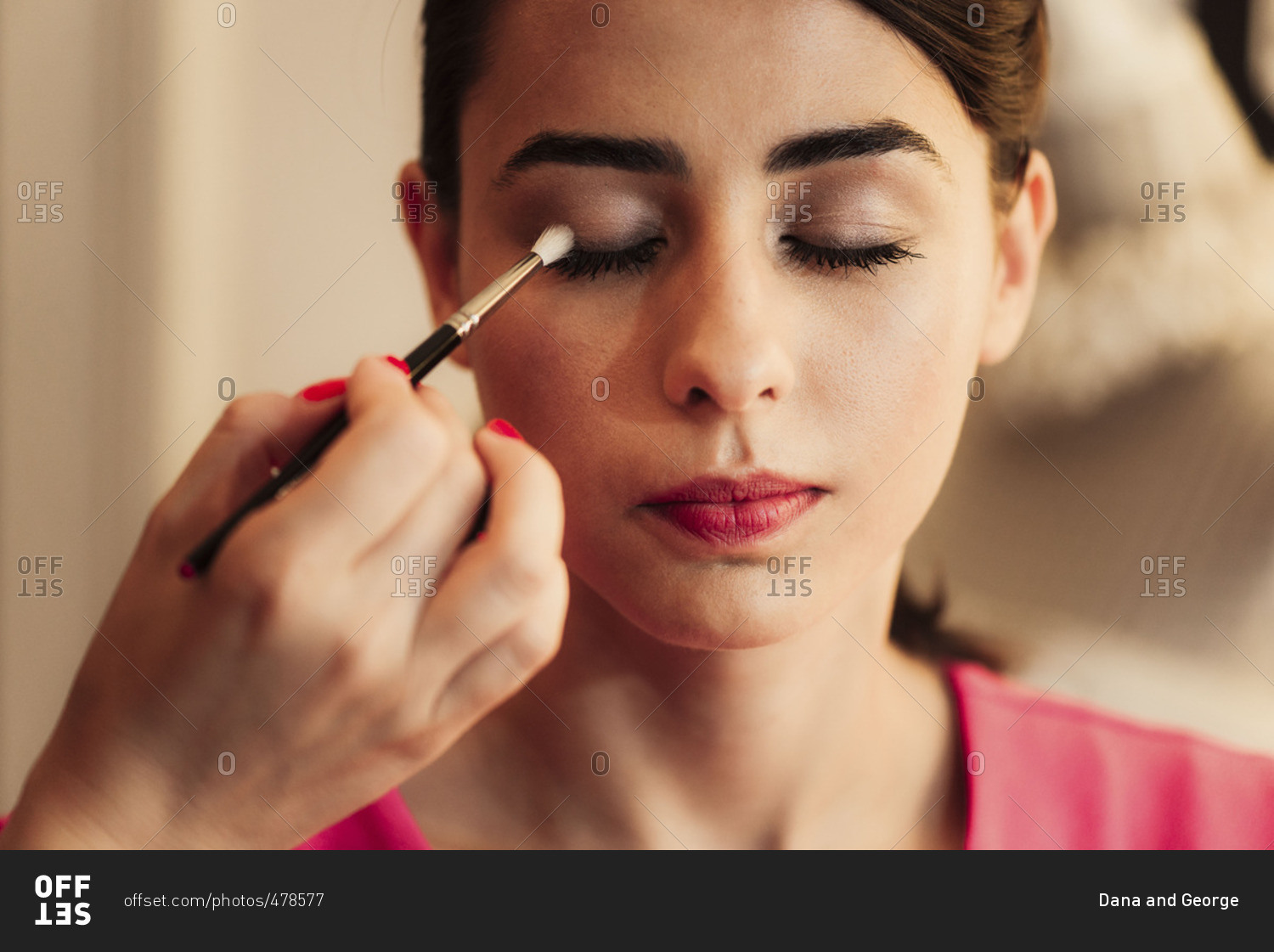 Woman having eye makeup put on